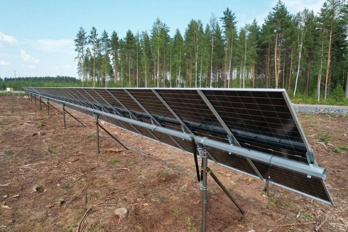 Solar panels installed on Helicasol helical pile and frame foundation, Nordic forest behind